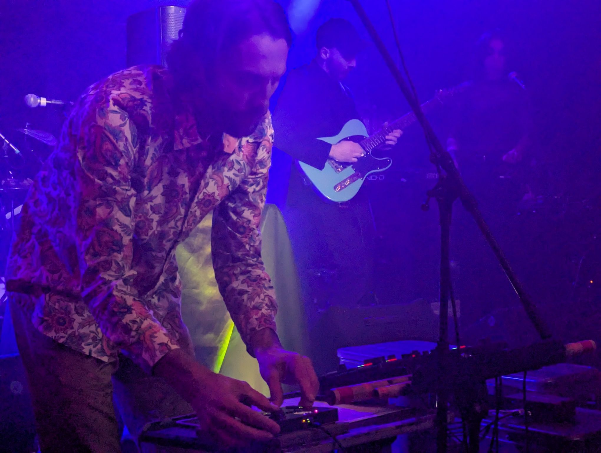 Musicians performing together under purple stage lighting